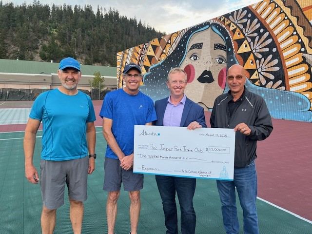 Jasper Park Racquet Club representatives receiving a Government of Alberta Community Facility Enhancement Program grant cheque on the club courts